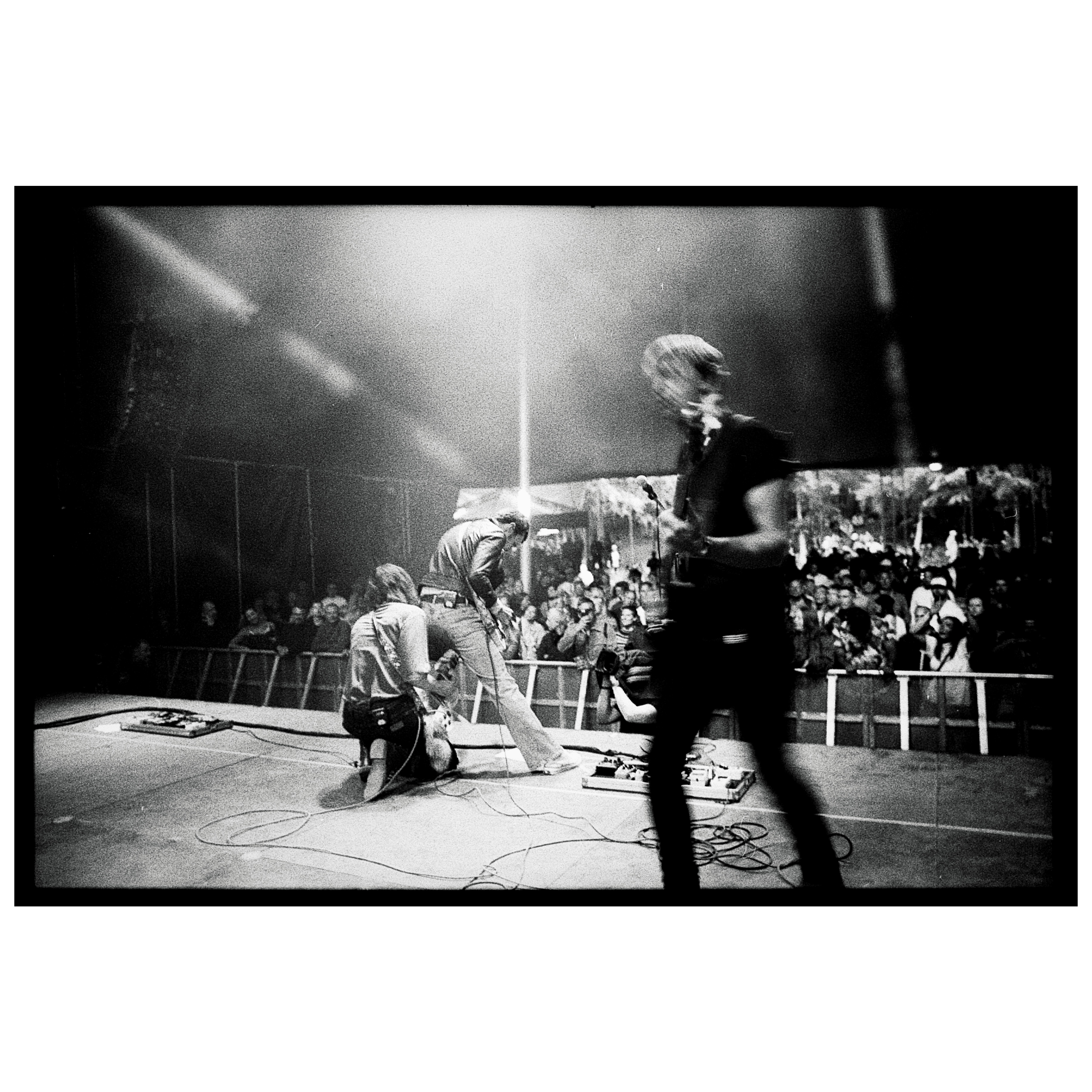 Tre mænd står på en scene og spiller musik